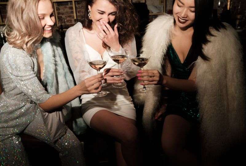 Three young women enjoying champagne in the MLC Connects Club.